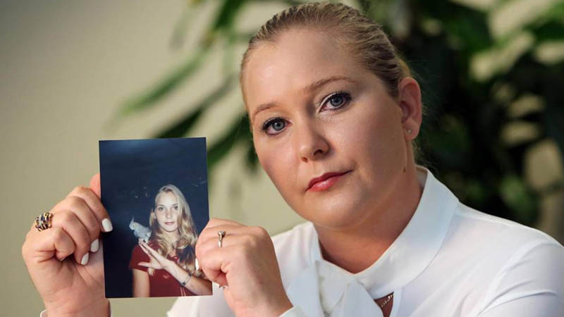 Virginia Roberts Giuffre holds a photo of herself at age 16